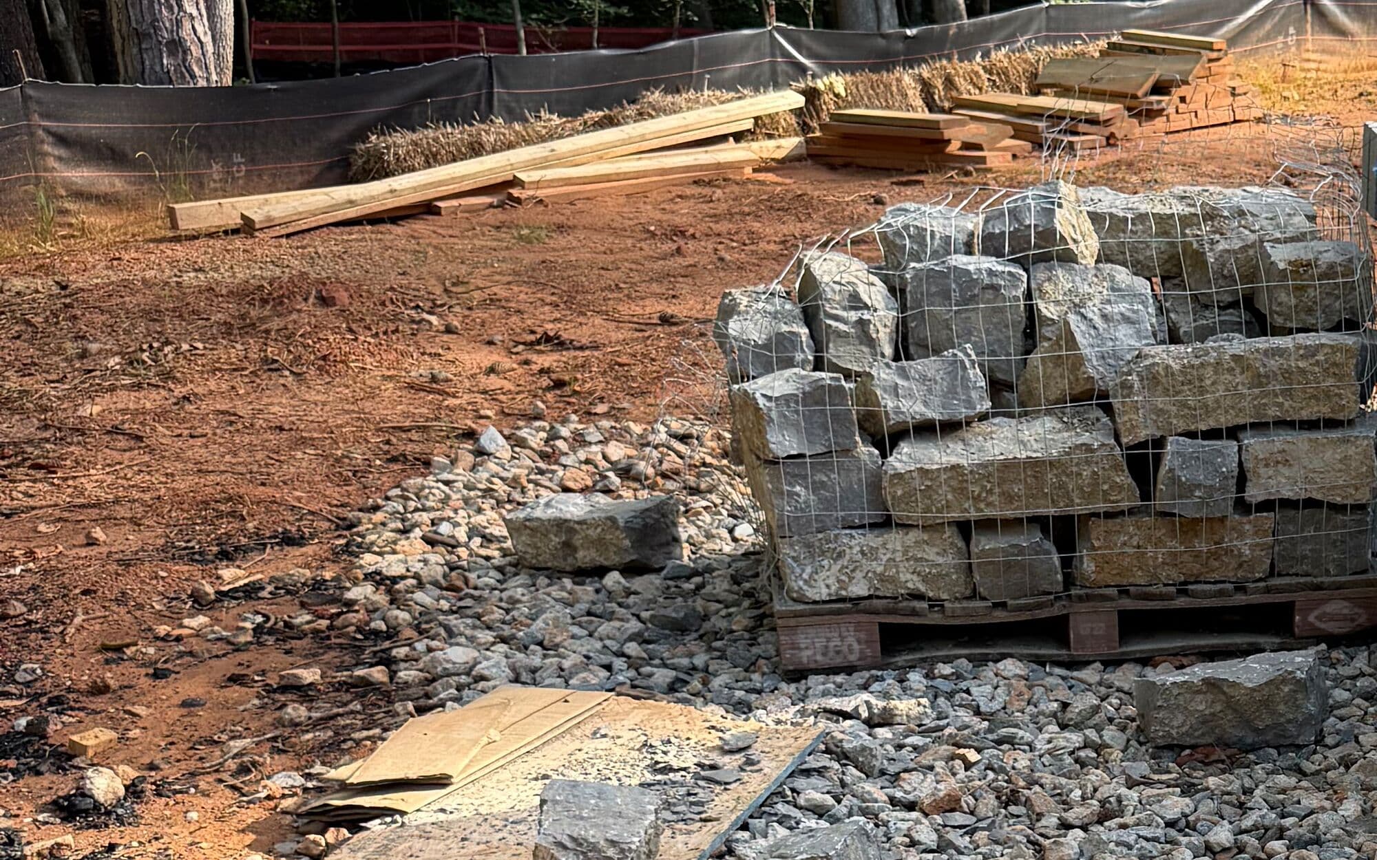 Tarima de piedra de corte rústico sobre una entrada de grava en una obra
