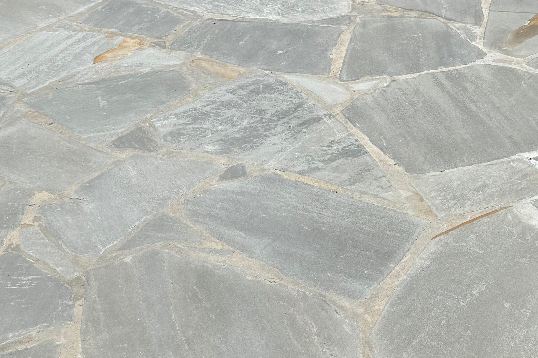 Grey flagstone pieces fitted tight with thin mortar joints