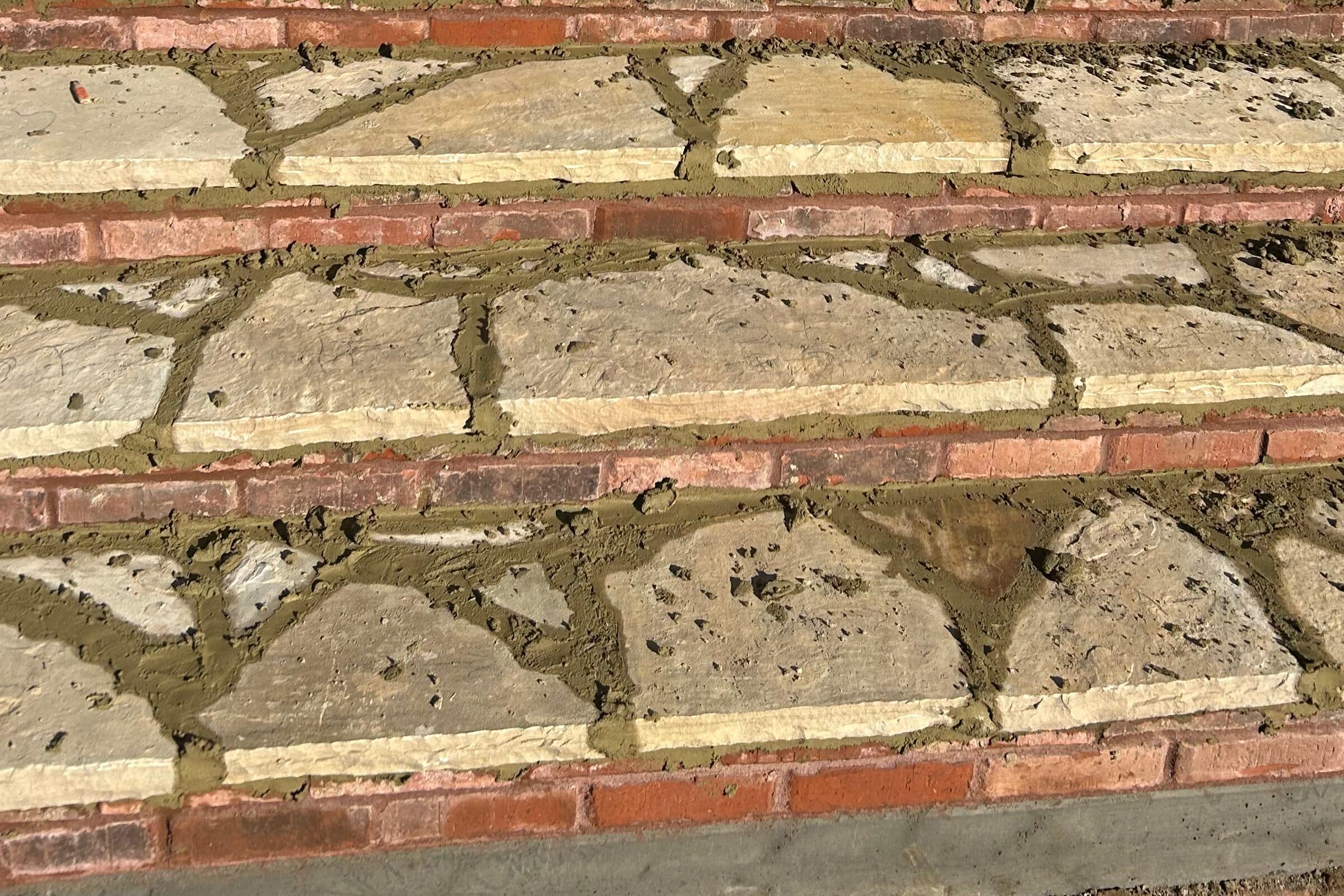 Fresh mortar joints between flagstone treads and brick risers