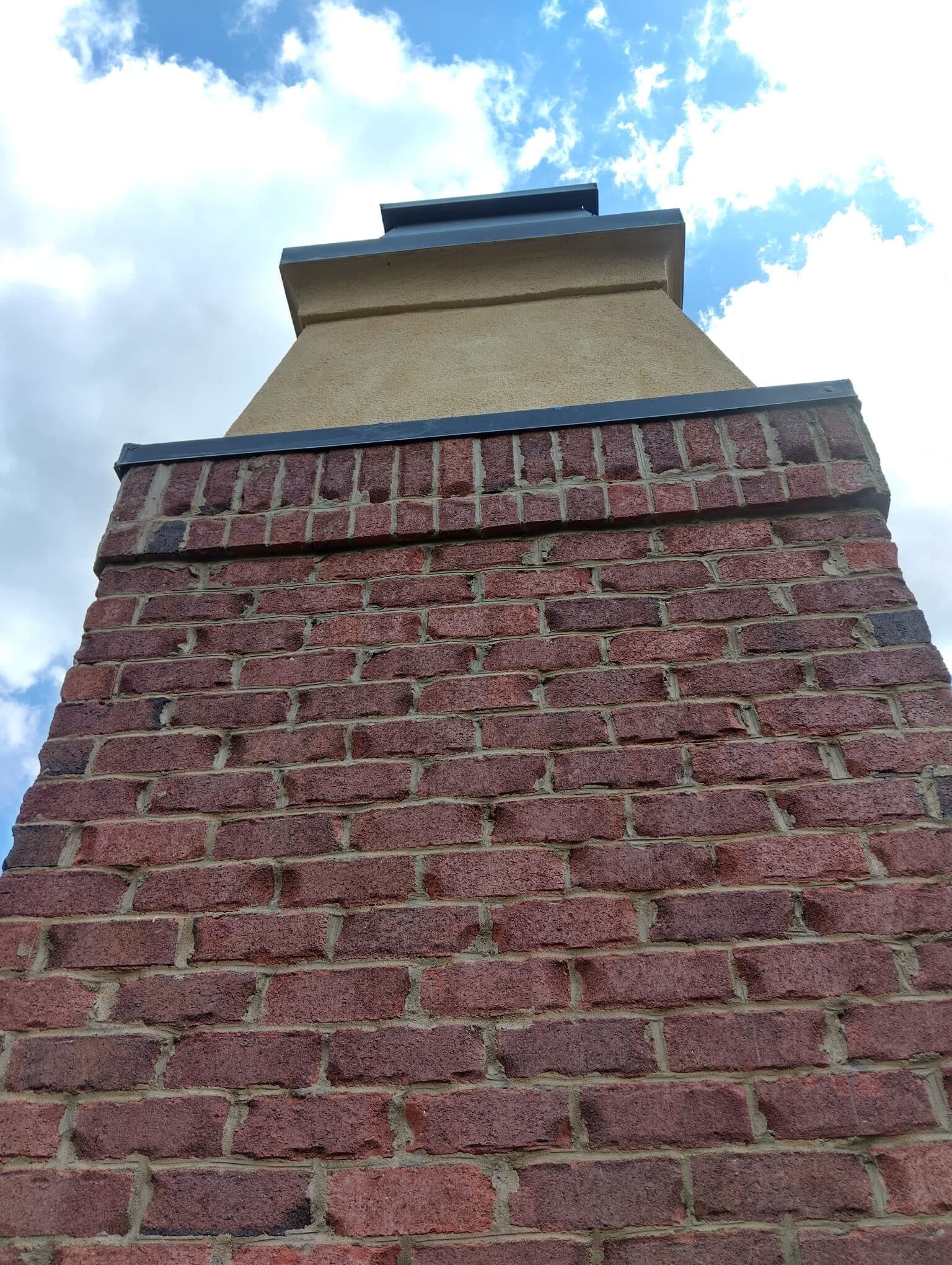 Chimenea de ladrillo rojo con un nuevo gotero de metal, vista desde abajo