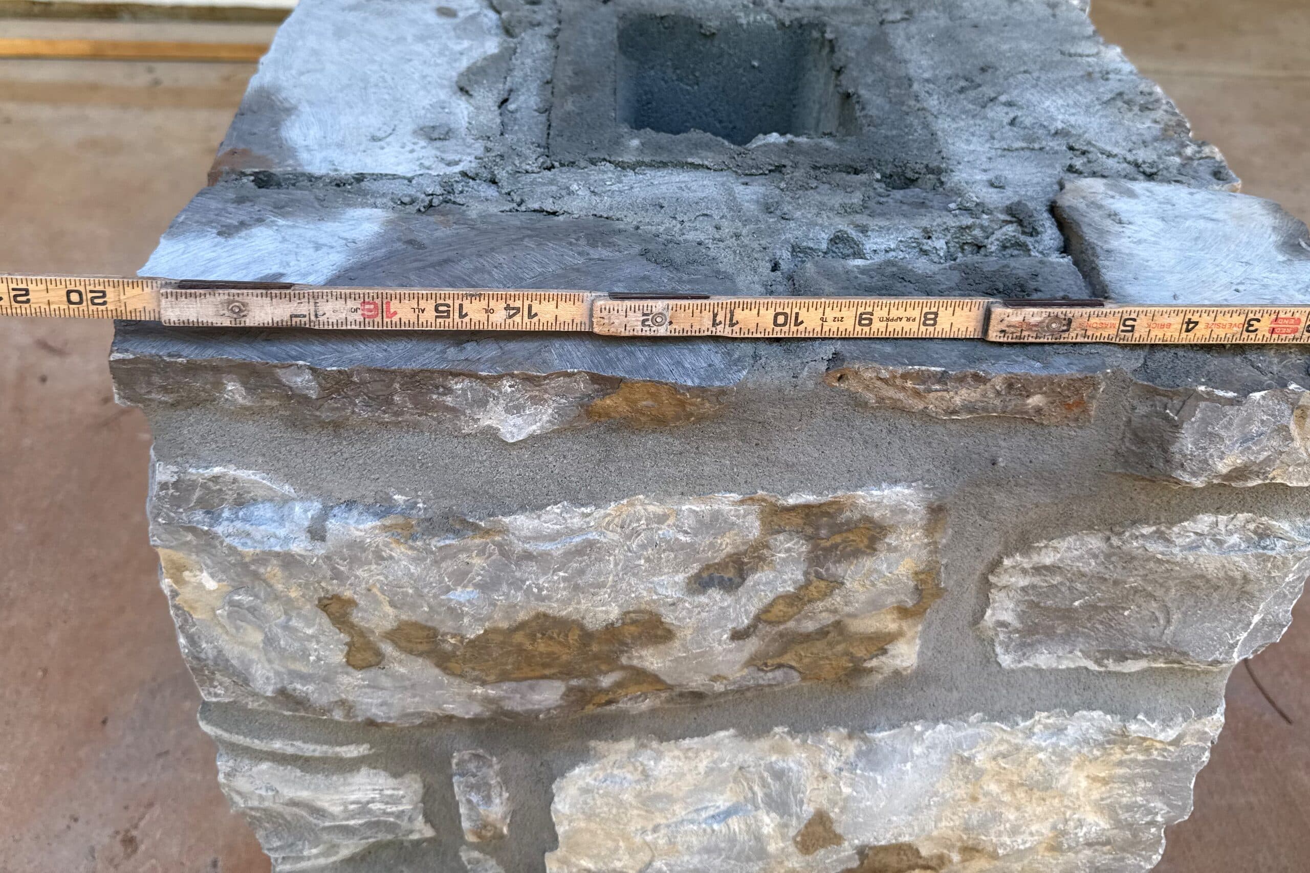 Parte superior de una columna de piedra natural con una regla plegable encima