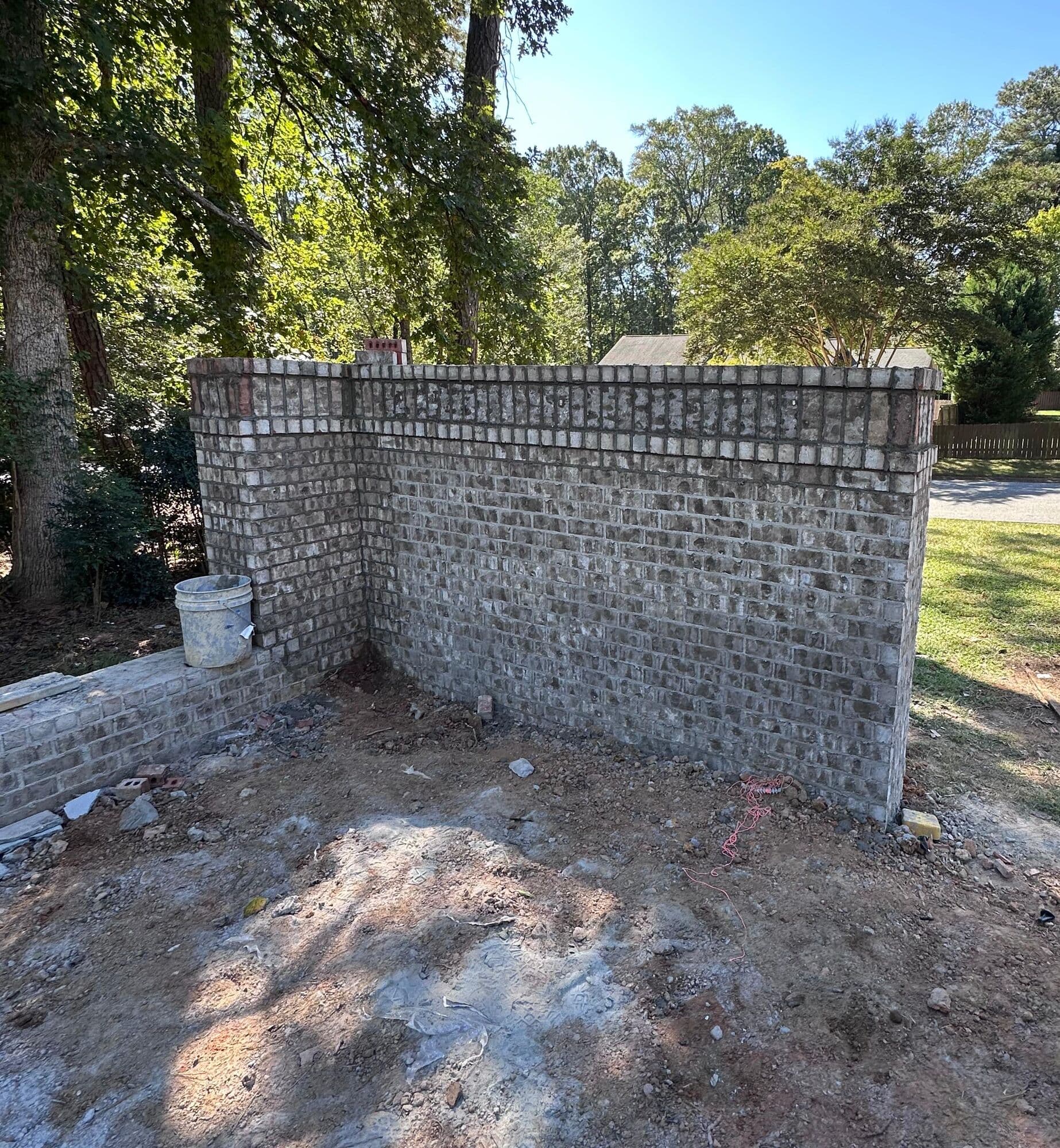 Esquina del muro de ladrillo terminado con su retorno y su hilada de remate