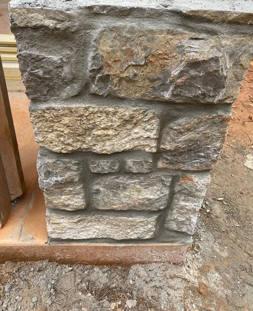 Natural stone column base with a mortared cap and a square anchor pocket in the top