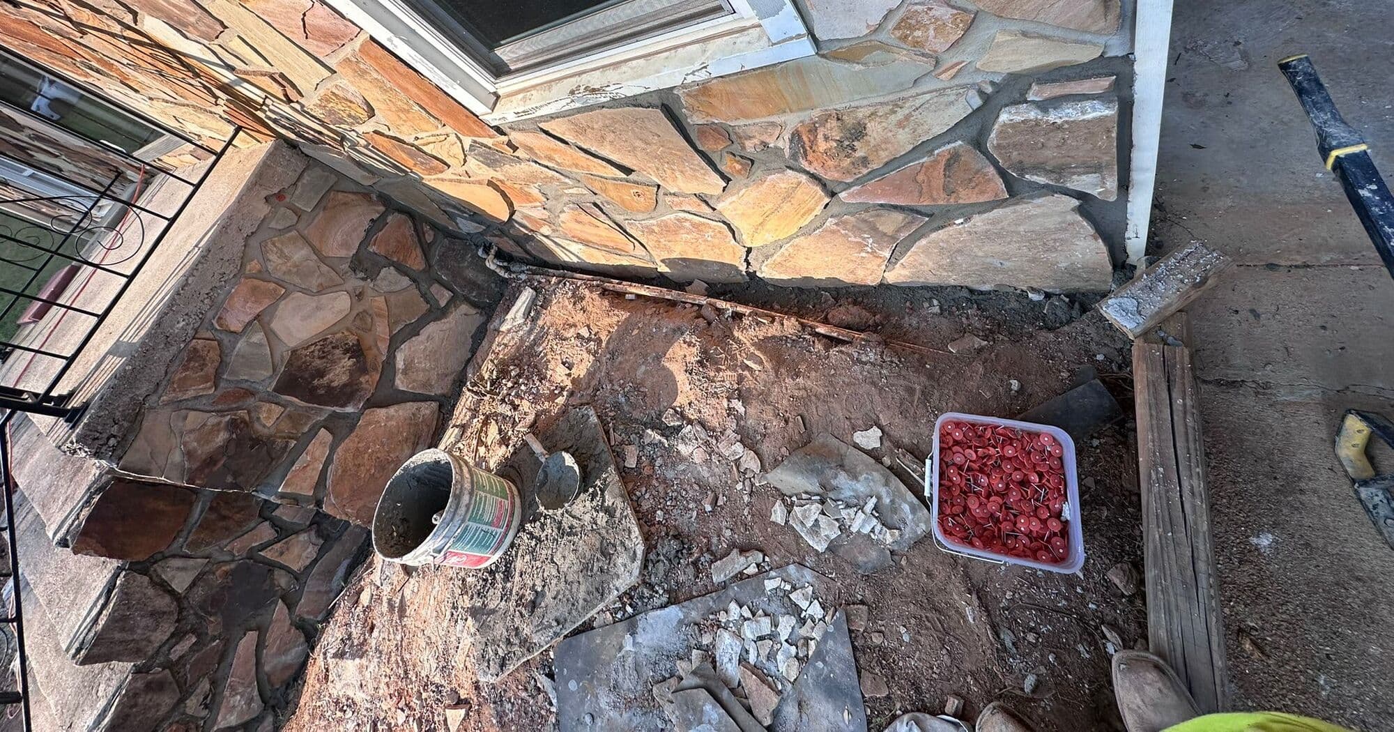 Broken stone and mortar at the base of the wall after the band came off