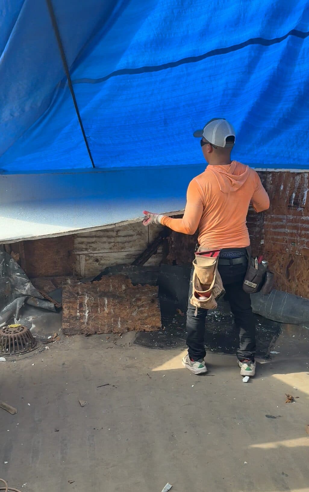 Franja vieja de estuco desprendiéndose del pretil del balcón, con el ladrillo detrás